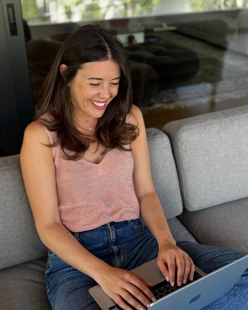 Angela laughing while she works on her laptop